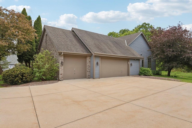 W313N4961 Chapel Ridge Rd, Hartland, WI 53029 - view of home's exterior with a garage, driveway, brick siding, and roof with shingles