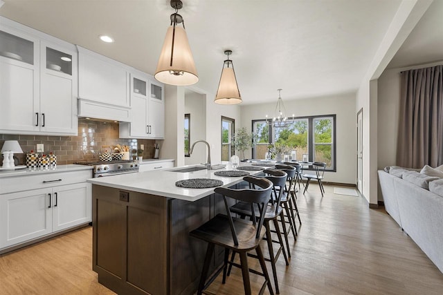 3812 Hawk Ledge Cir, De Pere, WI 54115 - kitchen featuring a sink, gas range, decorative backsplash, light wood-style floors, and recessed lighting