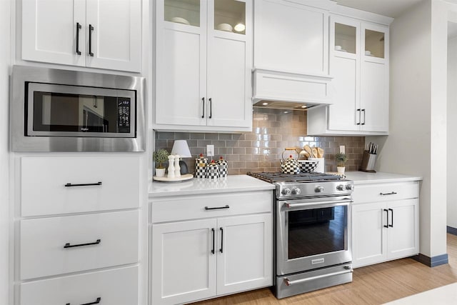3812 Hawk Ledge Cir, De Pere, WI 54115 - kitchen featuring appliances with stainless steel finishes, custom exhaust hood, light countertops, and backsplash