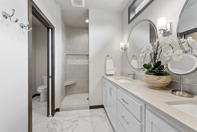 3812 Hawk Ledge Cir, De Pere, WI 54115 - bathroom featuring double vanity, marble finish floors, toilet, a tile shower, and baseboards