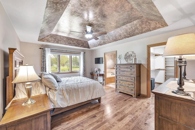 5125 Finger Rd, Green Bay, WI 54311 - bedroom featuring a raised ceiling, light wood-type flooring, ensuite bath, ceiling fan, and a spacious closet