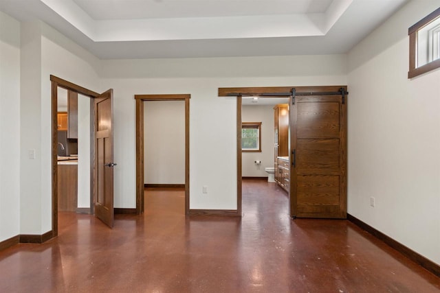 7947 Victoria Ct, Hewitt, WI 54441 - unfurnished bedroom with a barn door, a tray ceiling, finished concrete floors, and baseboards