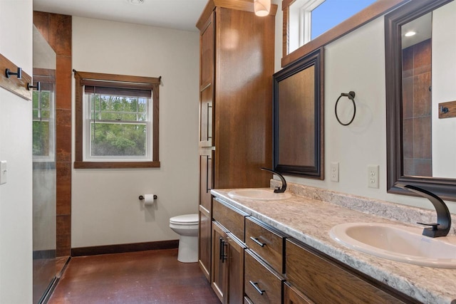 7947 Victoria Ct, Hewitt, WI 54441 - bathroom with double vanity, toilet, tiled shower, concrete flooring, and baseboards