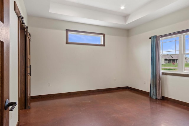 7947 Victoria Ct, Hewitt, WI 54441 - unfurnished room with finished concrete flooring, a tray ceiling, baseboards, a barn door, and recessed lighting