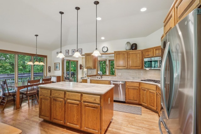 16625 Tanglewood Dr, Brookfield, WI 53005 - kitchen featuring stainless steel appliances, light countertops, a center island, decorative backsplash, and pendant lighting