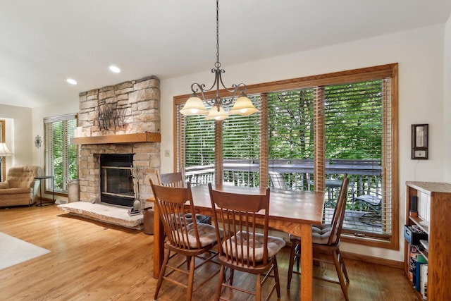 16625 Tanglewood Dr, Brookfield, WI 53005 - dining space featuring light wood-type flooring, a chandelier, a stone fireplace, and baseboards