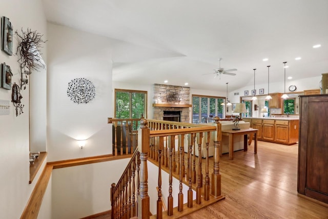 16625 Tanglewood Dr, Brookfield, WI 53005 - staircase featuring ceiling fan, vaulted ceiling, wood finished floors, and a stone fireplace