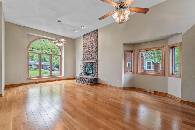 6241 N 118th St, Milwaukee, WI 53225 - unfurnished living room featuring ceiling fan, light wood-type flooring, a stone fireplace, and baseboards