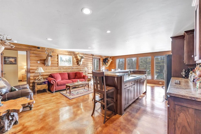 W12900 W Shore Dr, Crivitz, WI 54114 - kitchen with rustic walls, finished concrete floors, freestanding refrigerator, recessed lighting, and a breakfast bar area
