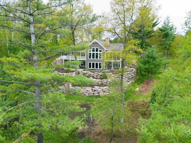 W12900 W Shore Dr, Crivitz, WI 54114 - back of property featuring a chimney, stairway, a wooden deck, and a forest view