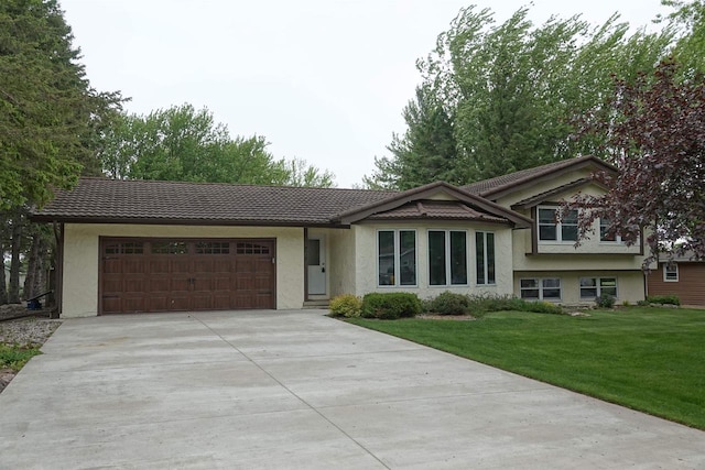 602 Dolf St, Colby, WI 54421 - split level home with stucco siding, an attached garage, concrete driveway, and a tiled roof
