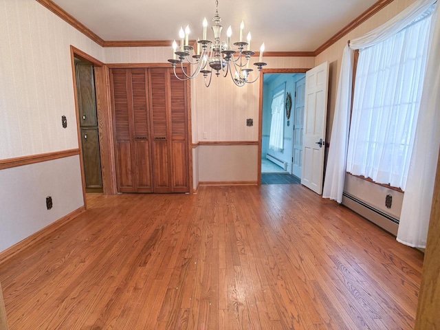315 Lampert St, Oshkosh, WI 54901 - unfurnished dining area featuring a chandelier, a baseboard radiator, wood finished floors, ornamental molding, and baseboards