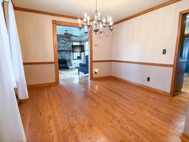 315 Lampert St, Oshkosh, WI 54901 - empty room featuring a chandelier, wood finished floors, crown molding, wallpapered walls, and ceiling fan