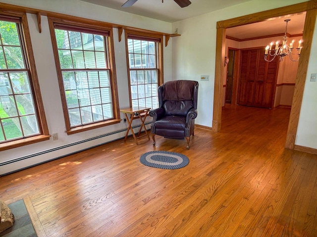 315 Lampert St, Oshkosh, WI 54901 - sitting room featuring a chandelier, a baseboard heating unit, wood-type flooring, and baseboards