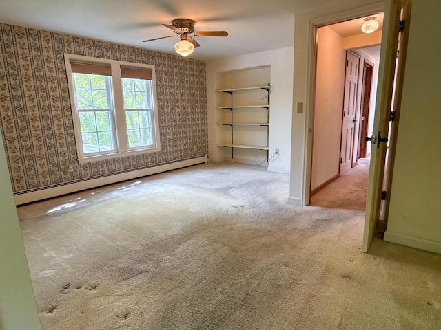 315 Lampert St, Oshkosh, WI 54901 - empty room featuring a baseboard radiator, ceiling fan, carpet, baseboards, and wallpapered walls
