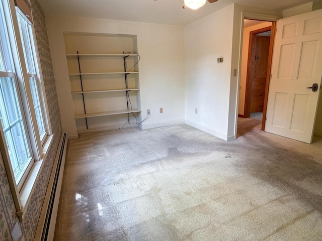 315 Lampert St, Oshkosh, WI 54901 - unfurnished room featuring carpet floors, a baseboard radiator, baseboards, and a ceiling fan