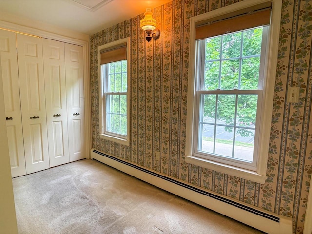 315 Lampert St, Oshkosh, WI 54901 - unfurnished bedroom with baseboard heating, wallpapered walls, multiple windows, a closet, and carpet