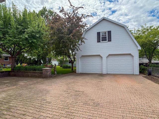 315 Lampert St, Oshkosh, WI 54901 - view of property exterior featuring a gambrel roof, a garage, and decorative driveway