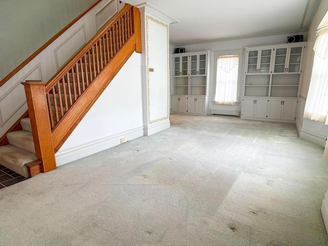 315 Lampert St, Oshkosh, WI 54901 - unfurnished living room with crown molding, light carpet, stairway, and a baseboard radiator