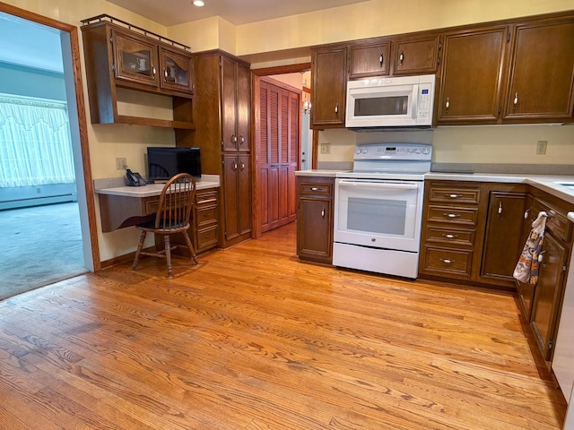 315 Lampert St, Oshkosh, WI 54901 - kitchen featuring white appliances, light wood-style flooring, light countertops, a desk, and a baseboard heating unit