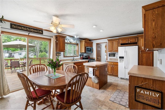 505 Lake Ave, Frederic, WI 54837 - dining room featuring a ceiling fan, a textured ceiling, light stone finish flooring, and ornamental molding