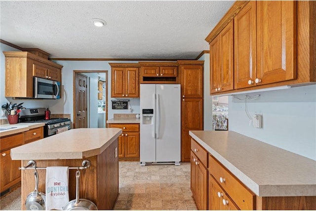 505 Lake Ave, Frederic, WI 54837 - kitchen with stainless steel appliances, light countertops, brown cabinetry, a center island, and a textured ceiling
