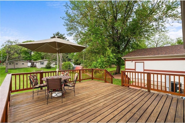 505 Lake Ave, Frederic, WI 54837 - wooden terrace featuring a lawn and outdoor dining area