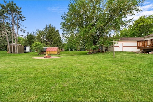 505 Lake Ave, Frederic, WI 54837 - view of green lawn featuring view of wooded area and a fire pit