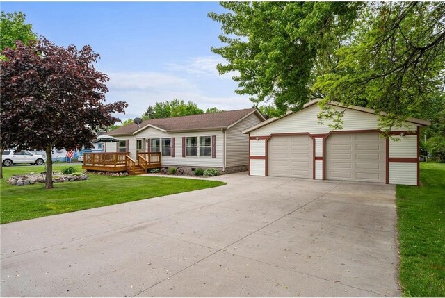 505 Lake Ave, Frederic, WI 54837 - view of front of home featuring a wooden deck, a detached garage, an outbuilding, and a front lawn