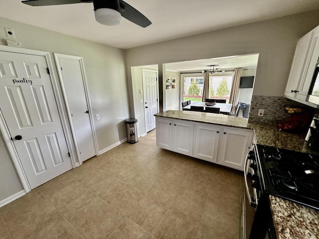 219 W Daphne St, Milwaukee, WI 53217 - kitchen with gas range oven, a ceiling fan, a peninsula, white cabinetry, and light tile patterned floors