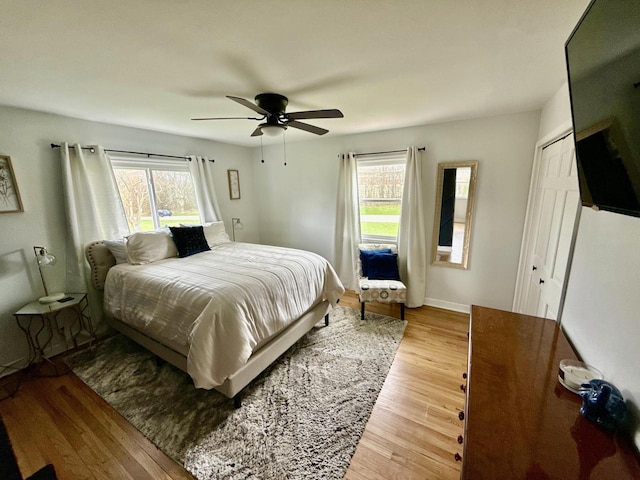 219 W Daphne St, Milwaukee, WI 53217 - bedroom featuring multiple windows, wood finished floors, a ceiling fan, and baseboards