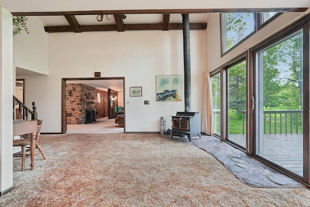 954 N Dousman Rd, Summit, WI 53066 - carpeted living area with a towering ceiling, a wood stove, beam ceiling, coffered ceiling, and baseboards