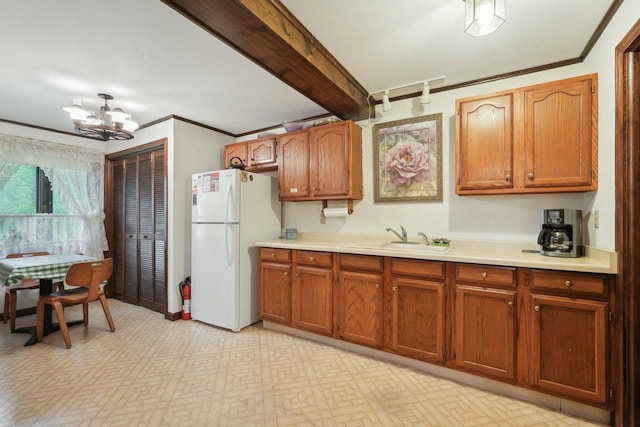 954 N Dousman Rd, Summit, WI 53066 - kitchen with freestanding refrigerator, a sink, light countertops, a chandelier, and brown cabinets