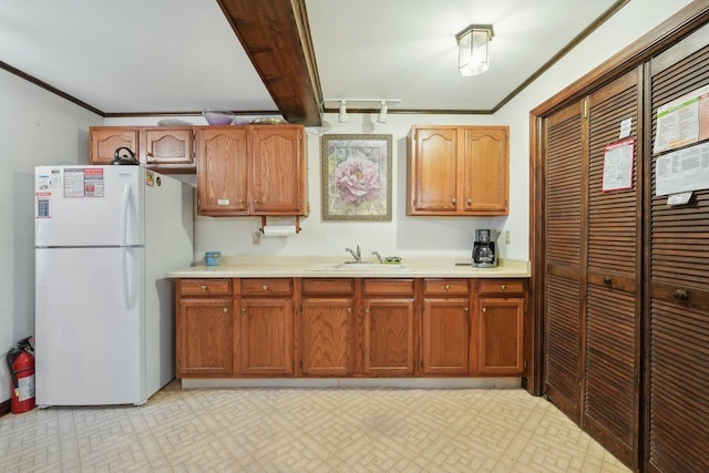 954 N Dousman Rd, Summit, WI 53066 - kitchen with freestanding refrigerator, a sink, crown molding, light countertops, and brown cabinets