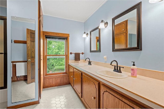 632 E 2nd St, New Richmond, WI 54017 - bathroom featuring radiator heating unit, double vanity, crown molding, and tile patterned flooring