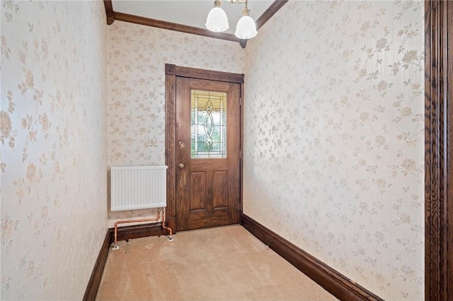 632 E 2nd St, New Richmond, WI 54017 - doorway to outside featuring radiator heating unit, ornamental molding, carpet flooring, and wallpapered walls