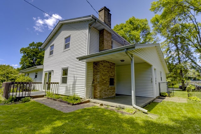 4705 Agate Ln, Madison, WI 53714 - rear view of house with a chimney, a lawn, a wooden deck, and brick siding