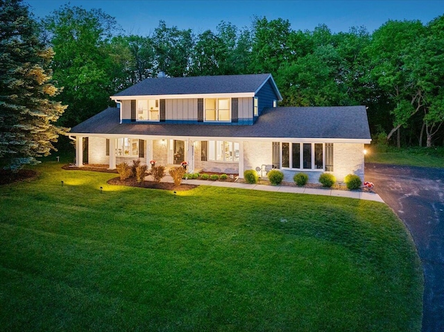 W308N5583 Windrise Cir, Hartland, WI 53029 - view of front of property with a front yard, driveway, and covered porch