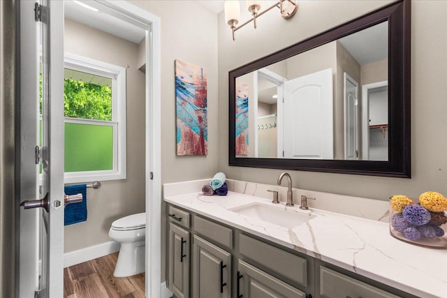 W308N5583 Windrise Cir, Hartland, WI 53029 - bathroom featuring vanity, toilet, wood finished floors, and baseboards