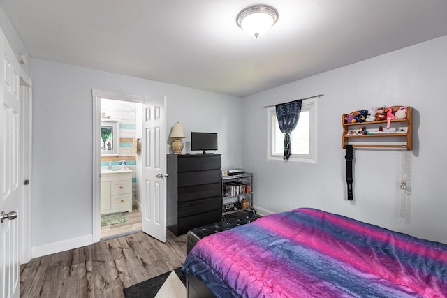 2921 Glendale Ave, La Crosse, WI 54601 - bedroom featuring wood finished floors, ensuite bath, and baseboards