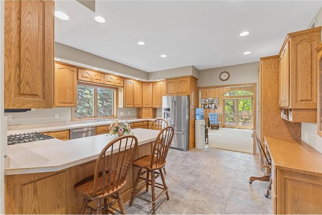 1115 S Trappers Xing, Hugo, MN 55038 - kitchen with appliances with stainless steel finishes, a peninsula, recessed lighting, light countertops, and a breakfast bar area