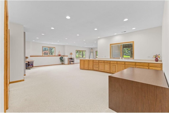 1115 S Trappers Xing, Hugo, MN 55038 - kitchen featuring recessed lighting, light colored carpet, open floor plan, baseboards, and a sink