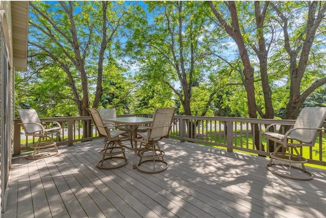 1115 S Trappers Xing, Hugo, MN 55038 - wooden terrace featuring outdoor dining area and view of wooded area