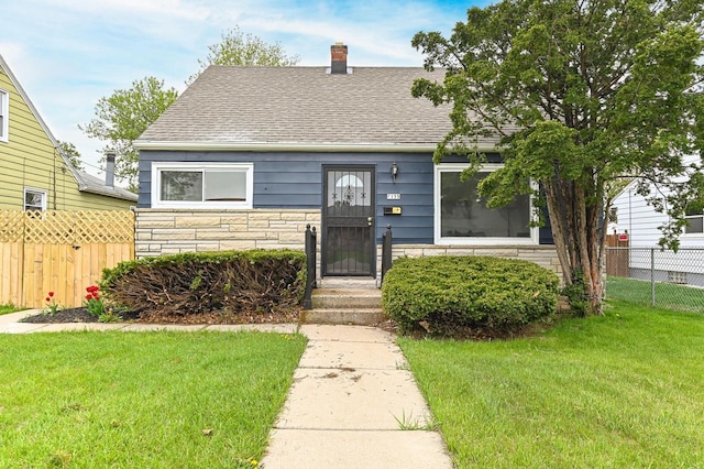 4155 N 67th St, Milwaukee, WI 53216 - view of front of home with stone siding, roof with shingles, and a chimney