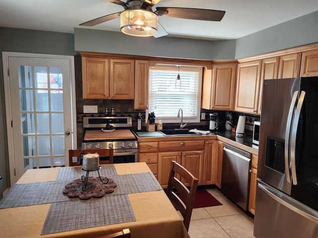 3617 S 80th St, Milwaukee, WI 53220 - kitchen with stainless steel appliances, a sink, ceiling fan, decorative backsplash, and light tile patterned floors