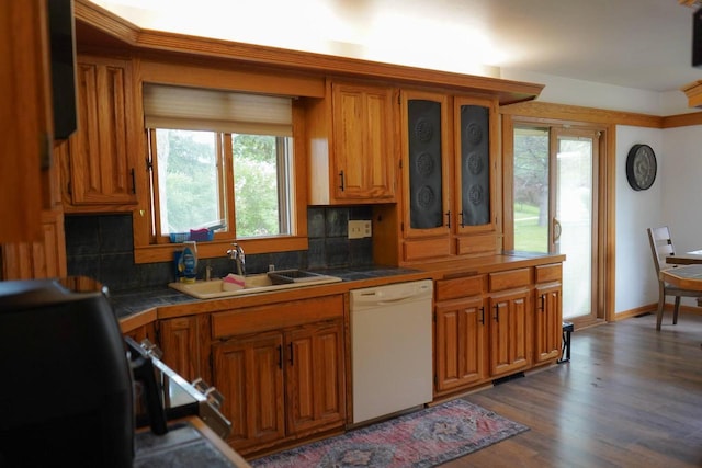 3867 S Massachusetts Ave, Milwaukee, WI 53220 - kitchen with white dishwasher, brown cabinetry, a sink, and tasteful backsplash