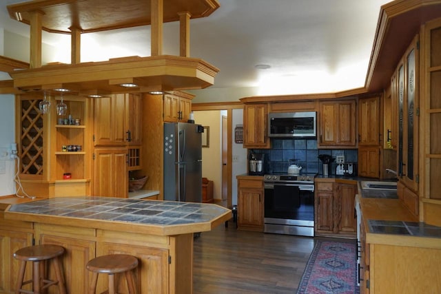 3867 S Massachusetts Ave, Milwaukee, WI 53220 - kitchen with stainless steel appliances, tile counters, a sink, and backsplash