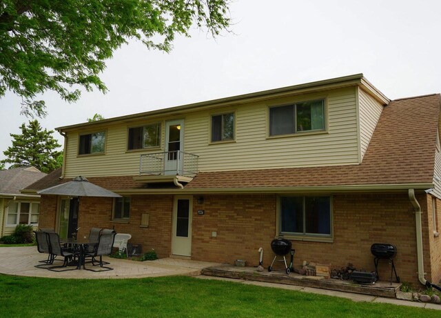 3867 S Massachusetts Ave, Milwaukee, WI 53220 - back of house with a balcony, brick siding, a patio, and a shingled roof