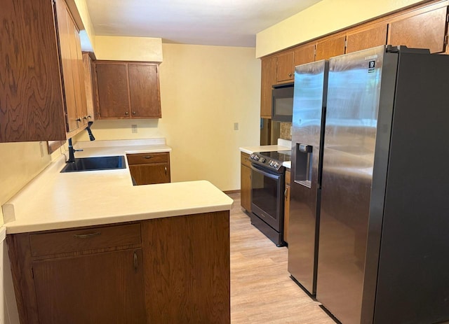 1124 Tullar Rd, Neenah, WI 54956 - kitchen featuring stainless steel fridge, black range with electric stovetop, a sink, a peninsula, and light countertops