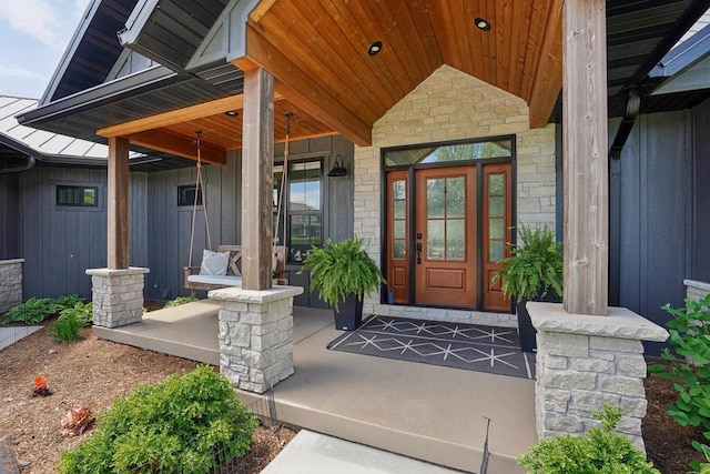 E12785 Wynding Way, Merrimac, WI 53561 - doorway to property with covered porch, stone siding, and board and batten siding